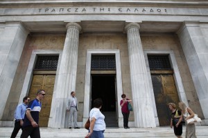 People walk outside the Bank of Greece in Athens