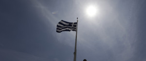 A Greek flag waves as tourists enjoy the view atop of the ancient Acropolis hill in Athens, on Monday, May 9, 2016. European finance ministers are trying to break a deadlock over whether to provide Greece with the next batch of bailout loans, which it needs to avoid bankruptcy this year, and forgive some of its debts. (AP Photo/Thanassis Stavrakis)