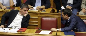 Greece's Prime Minister Alexis Tsipras, right, speaks with Finance Minister Euclid Tsakalotos during an emergency parliament session in Athens, Wednesday, July 22, 2015. Greece's liquidity-starved banks got a new cash injection from the European Central Bank on Wednesday, hours before a key vote in parliament on further economic reforms demanded by international creditors in return for a third bailout. (AP Photo/Thanassis Stavrakis)