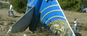 Police officers walk behind the tail of the crashed Cypriot Helios plane on a hillside in Grammatiko, 40 kilometers (25 miles) north of Athens, Greece on Monday, Aug. 22, 2005. A Cypriot airliner that crashed on Aug. 14, killing all 121 people on board, suffered loss of cabin pressure and ran out of fuel before slamming into a mountain near Athens, a preliminary report found, according to state television. The findings were presented to the transport ministry by chief investigator Akrivos Tsolakis, following the analysis of flight recorders and autopsies on all 118 bodies recovered from the site. (AP Photo/Petros Giannakouris)