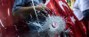 Demonstrators seen through a hole in hotel`s a window near Istanbul's Taksim Square wave Turkish flags on July 24, 2016 during the first cross-party rally to condemn the coup attempt against President Recep Tayyip Erdogan. Many thousands of flag-waving Turks massed Sunday for the first cross-party rally to condemn the coup attempt against President Recep Tayyip Erdogan, amid an ongoing purge of suspected state enemies. But in stark contrast to the celebratory and patriotic mood in Istanbul, human rights group Amnesty International in London claimed it had "credible evidence" of the beating and torture of detainees. / AFP / OZAN KOSE (Photo credit should read OZAN KOSE/AFP/Getty Images)