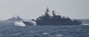 Turkish NATO warship TCG Turgutreis, foreground, maneuvers on the Black Sea after leaving the port of Constanta, Romania, Monday, March 16, 2015, as an explosion takes place in the distance. NATO ships take part in sea military exercises in the Black Sea region involving ships USS Vicksburg, as well as a German auxiliary ship and frigates from Canada, Turkey, Italy and Romania. (AP Photo/Vadim Ghirda)