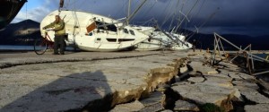 A man pushes his bicycle in the port of the city of Lixouri, that has damaged by the recent strong 6.1 magnitude earthquake, on February 4, 2014. A strong earthquake hit the Greek island of Cephalonia early on February 3 , causing further damage to homes and public buildings a week after another major tremor The quakes have cracked the wharf of Lixouri and surrounding roads and disrupted the electricity supply. The island's schools are temporarily shut. AFP PHOTO / KOSTIS NTANTAMIS (Photo credit should read KOSTIS NTANTAMIS/AFP/Getty Images)