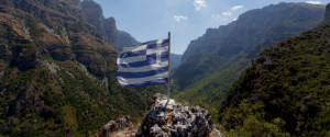 ZAGOROHORIA, GREECE - AUGUST 11: Greek flag infront the mountain range of Timfis near Papingo village on August 11, 2016 in Zagorohoria, Greece. Papingo actually consists of two villages Megalo Papingo and Mikro Papingo the big one and small Papingo. (Photo by Athanasios Gioumpasis/Getty Images)