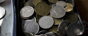 Old Greek drachma currency coins sit in a box at an antique dealer's store in Thessaloniki, Greece, on Wednesday, May 27, 2015. Greek banks, forced into a central bank liquidity lifeline, are poised to report sustained losses as they grapple with record deposit outflows and an economy that plunged into double-dip recession. Photographer: Konstantinos Tsakalidis/Bloomberg via Getty Images