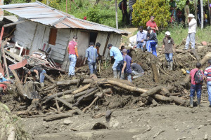 Residents rescue belongings from houses damaged during an avalanche in Salgar, in Colombia's northwestern state of Antioquia, Monday, May 18, 2015. At least 49 people were killed when a mudslide triggered by heavy rains swept away homes before dawn. (AP Photo/Luis Benavides)